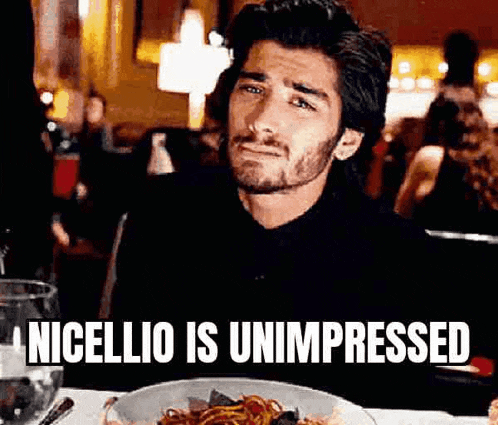 a man is sitting at a table with a plate of food and a glass of water .