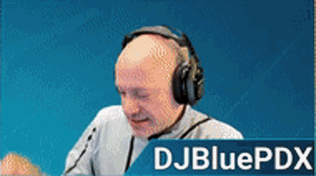 a man wearing headphones is sitting in front of a microphone with the name djbluepdx on the bottom