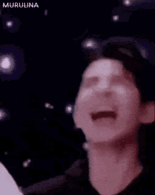 a man is making a funny face with his mouth open in a blurry photo .