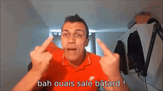 a man wearing a red nike shirt giving the middle finger