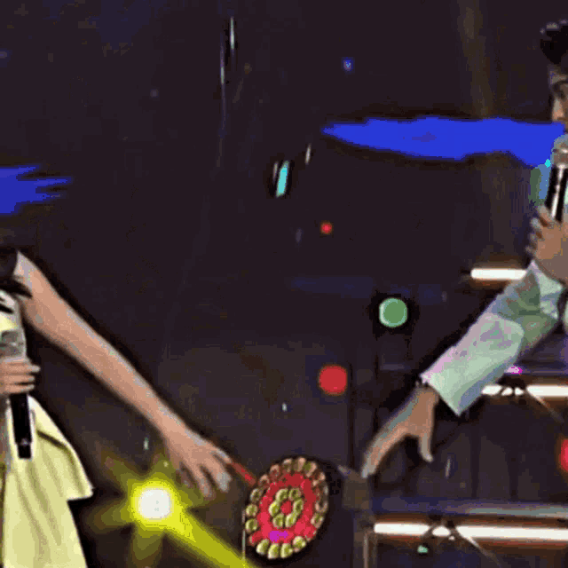 a man is holding a woman 's hand while holding a microphone