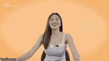 a woman in a white tank top is smiling and holding a pen with imgflip.com written below her