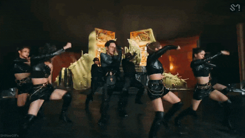a man is standing in front of a group of women dancing in a room .