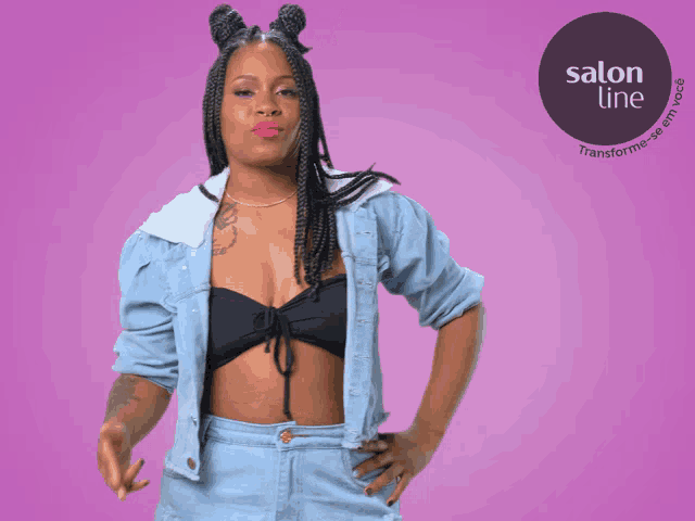 a woman wearing a denim jacket and a black crop top stands in front of a salon line logo