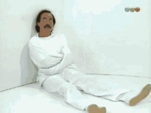 a row of men in straitjackets are sitting next to each other