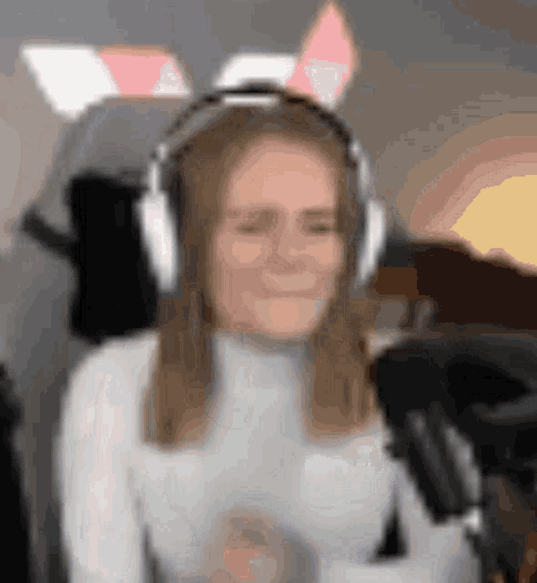 a woman wearing bunny ears is sitting in front of a microphone with her eyes closed .