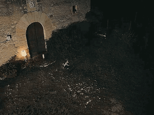a lamp is lit up in front of a stone door