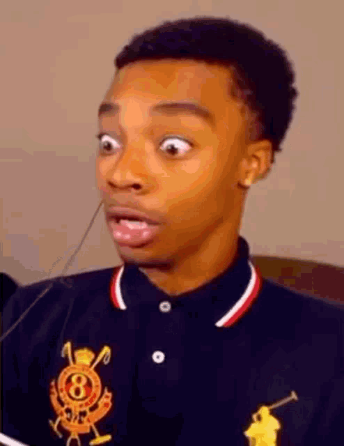 a young man wearing a polo shirt is making a funny face .