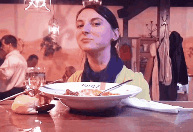 a woman is sitting at a table with a bowl of food that says ' peru ' on the bowl