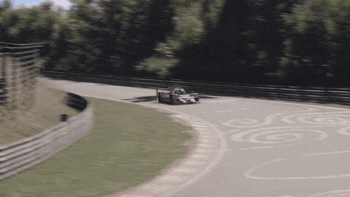 a race car is driving down a track with a swirl pattern on it