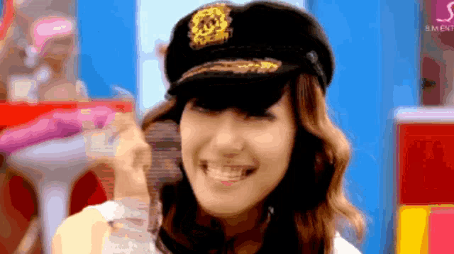 a woman wearing a hat with a lion on it is smiling