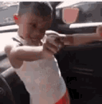 a little boy is sitting in the back seat of a car holding someone 's hand .