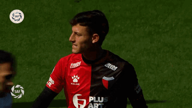a soccer player wearing a black and red jersey with the number 6 on it