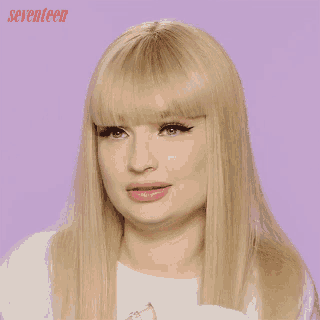 a woman with blonde hair and bangs is making a funny face with the words seventeen behind her