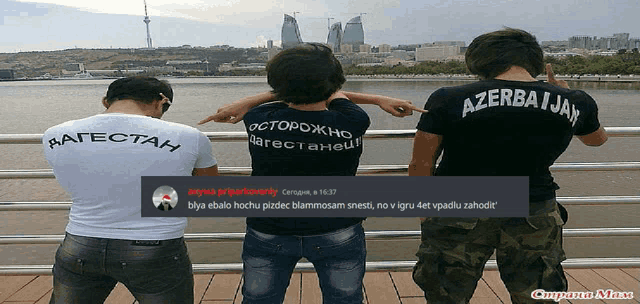 three men wearing shirts that say azerbaijan are pointing at something