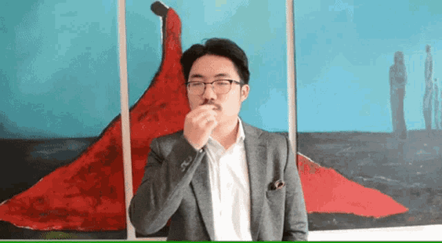 a man in a suit stands in front of a painting