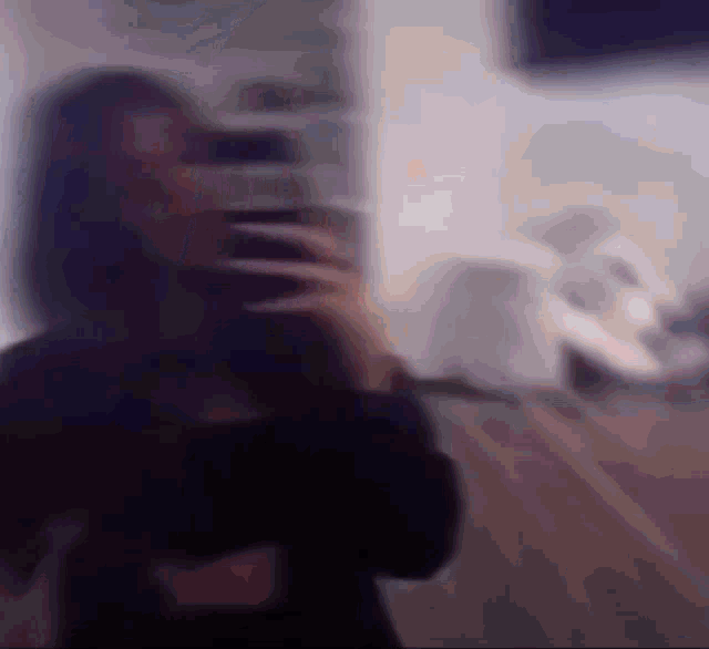 a blurry picture of a woman taking a selfie with her cell phone