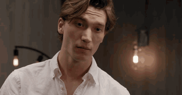 a close up of a man 's face with a light bulb behind him