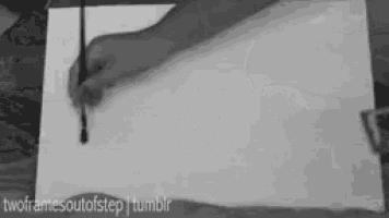 a black and white photo of a person drawing with a pencil