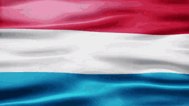 a red white and blue flag is being blown in the wind