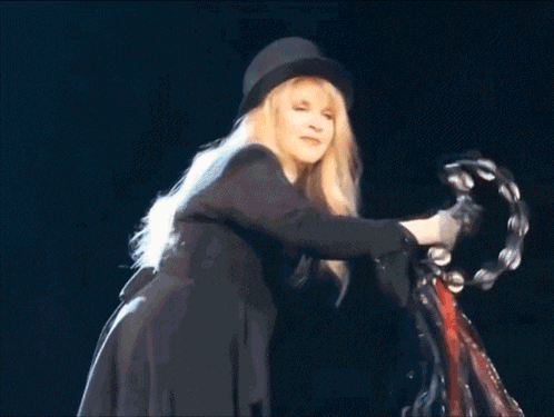 a blonde woman wearing a top hat and black jacket