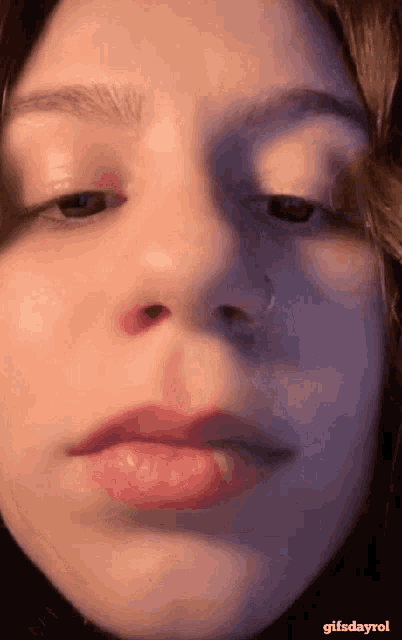 a close up of a woman 's face with a nose ring on it