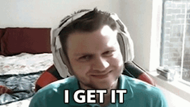 a man wearing headphones and a towel on his head is making a funny face and saying i get it .