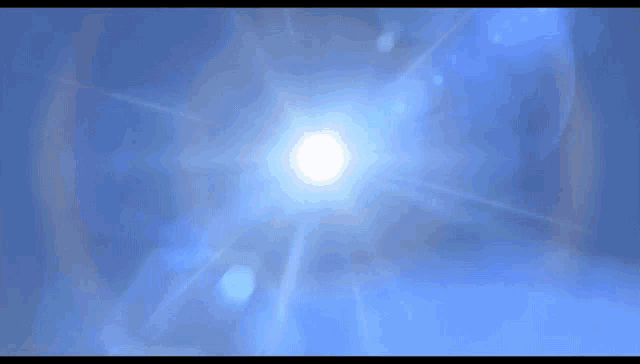 a person 's hand is reaching out towards the sun in a blue sky