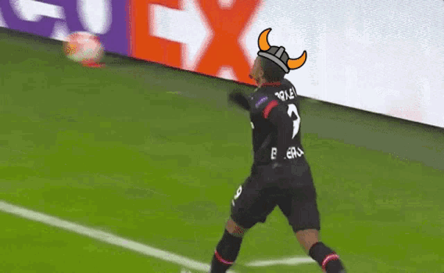 a soccer player wearing a viking hat is kicking a ball