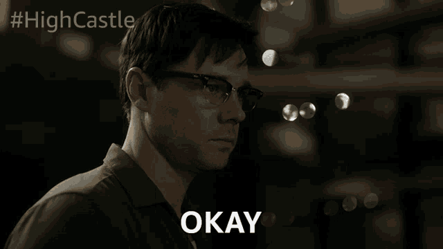 a man wearing glasses says okay in front of a #highcastle logo