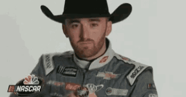 a man wearing a cowboy hat is holding a ring in his hand .