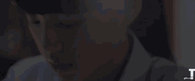 a close up of a person 's face while sitting at a table with their eyes closed .