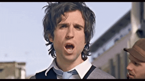 a man wearing a tie is making a funny face with his mouth open