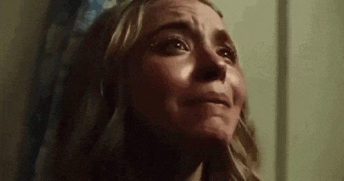 a close up of a woman 's face with tears coming out of her eyes .