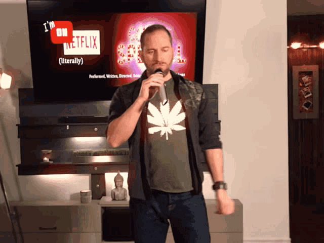 a man singing into a microphone in front of a screen that says i 'm on netflix literally