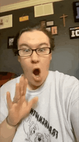 a woman wearing glasses is taking a selfie with her mouth open .