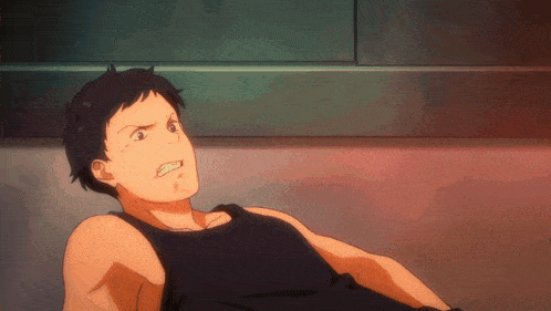 a man in a black tank top laying on the floor