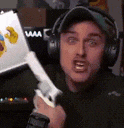 a man wearing headphones and a hat is holding a wii remote controller .