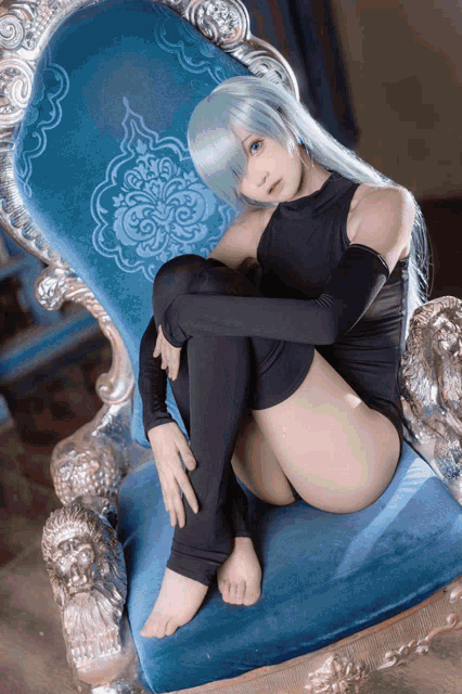 a woman in a costume is sitting on a chair with her legs crossed