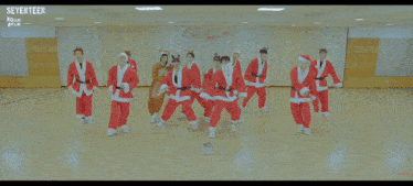 a group of people dressed in santa outfits are performing a dance
