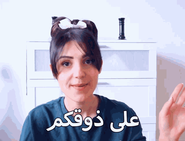 a woman with a bow in her hair is talking in arabic