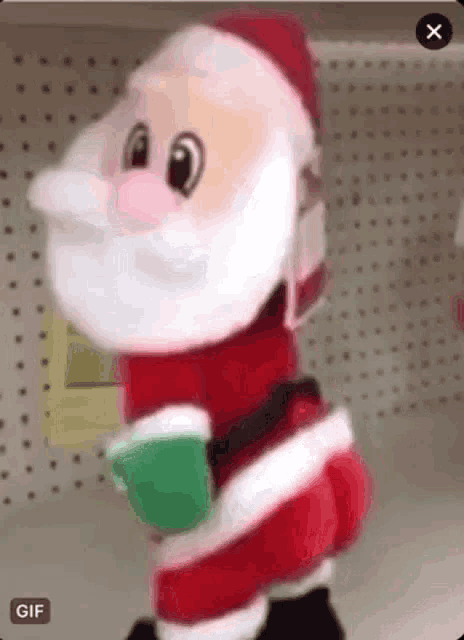 a blurry picture of a stuffed santa claus holding a cup of coffee