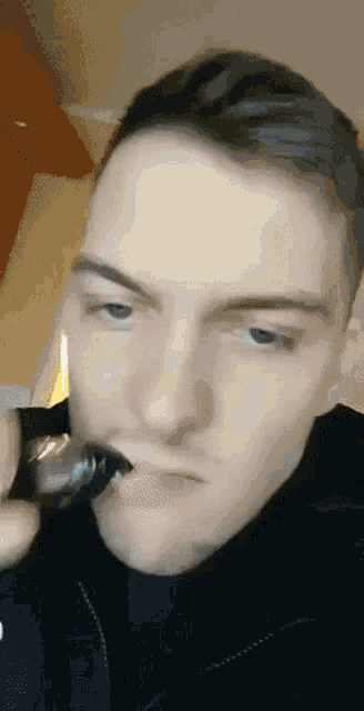 a close up of a man 's face with a cigarette in his mouth