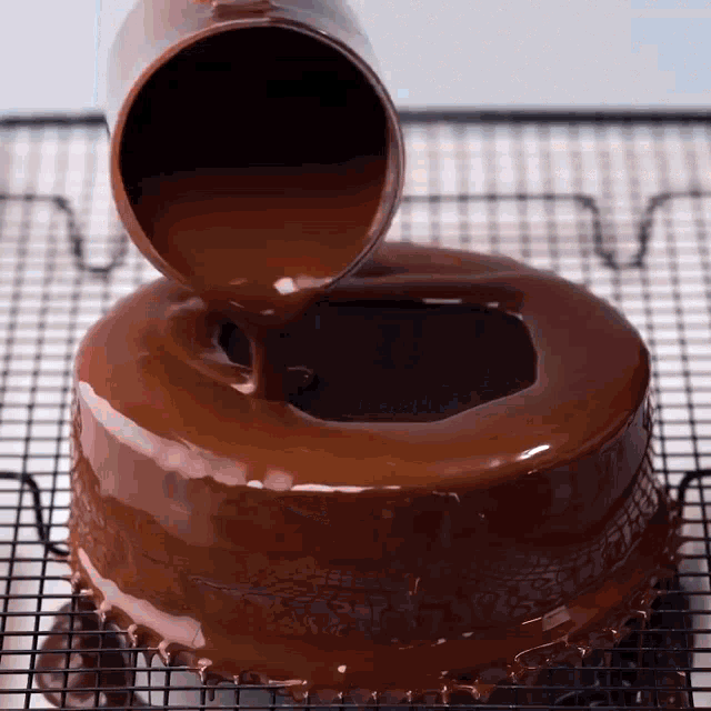 a chocolate cake is being covered with chocolate sauce