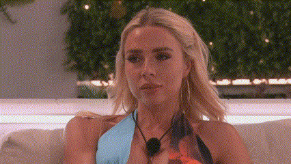 a woman in a bikini is sitting on a couch with a microphone around her neck .