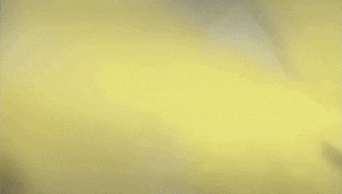 a close up of a person 's face surrounded by yellow smoke .