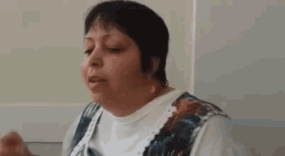 a woman is sitting at a table with a fork in her hand and eating food .