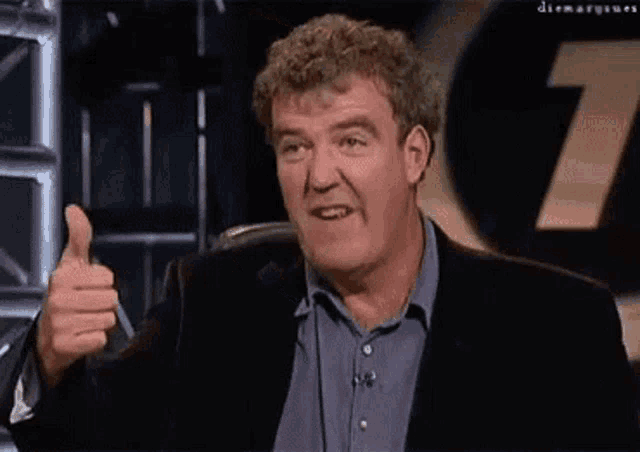 a man in a suit giving a thumbs up