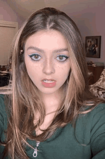 a close up of a woman taking a selfie in her room .