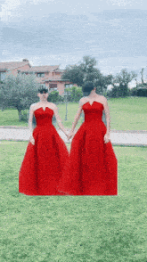 two women in red dresses are standing next to each other holding hands